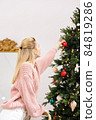 woman is decorating Christmas tree 84819286