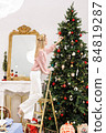 woman is decorating Christmas tree 84819287