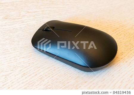 Close up of wireless computer mouse on white wooden background Close up of wireless computer mouse on white wooden background 84819436