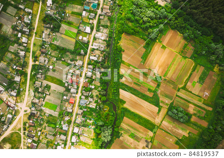 Aerial View Of Vegetable Gardens In Small Town Or Village. Skyline In Summer Evening. Village Garden Beds In Bird's-eye View Aerial View Of Vegetable Gardens In Small Town Or Village. Skyline In Summer Evening. Village Garden Beds In Bird's-eye View 84819537