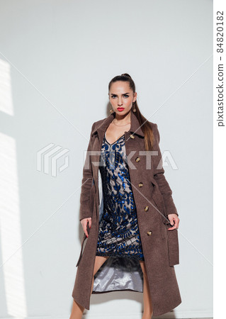 beautiful woman in a warm brown coat on a white background beautiful woman in a warm brown coat on a white background 84820182