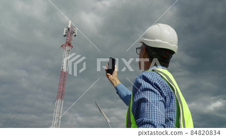 Telecommunications engineer checking the signal from a telecommunications tower. 84820834