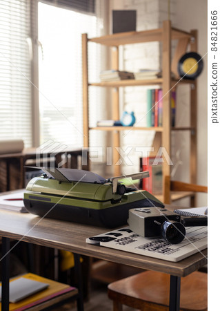 Vintage old film camera and typewriter at wooden desk table Vintage old film camera and typewriter at wooden desk table 84821666