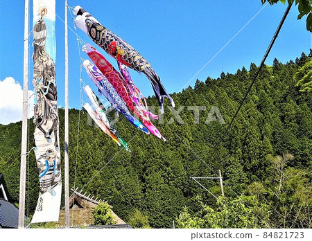 Carp streamer swimming against the blue sky and mountains, father carp, mother carp, three children's carp, warrior picture streamer next to it, thatched roof 84821723