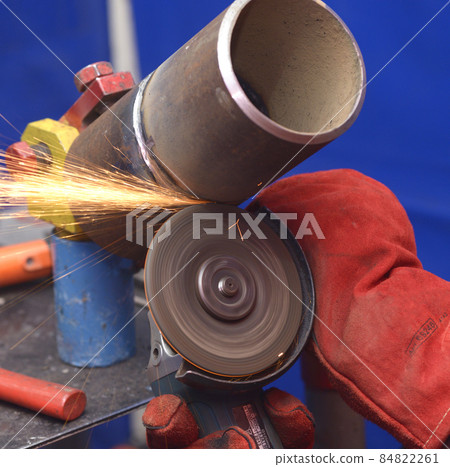 worker hands grinding metal tube with a grinder, preparing for welding worker hands grinding metal tube with a grinder, preparing for welding 84822261