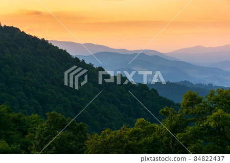 mountain ridge at dusk. scenic landscape with forested hills in evening light. sky with glowing clouds. beaautiful nature scenery in summer mountain ridge at dusk. scenic landscape with forested hills in evening light. sky with glowing clouds. beaautiful nature scenery in summer 84822437