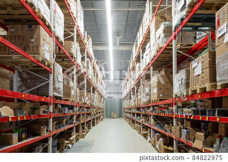 interior of a huge warehouse with long red racks and cardboard boxes, blurred photography, defocus interior of a huge warehouse with long red racks and cardboard boxes, blurred photography, defocus 84822975