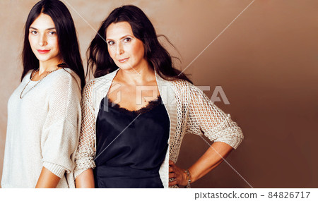 cute pretty teen daughter with mature mother hugging, fashion style brunette makeup close up tann s together, warm colors cute pretty teen daughter with mature mother hugging, fashion style brunette makeup close up tann s together, warm colors 84826717