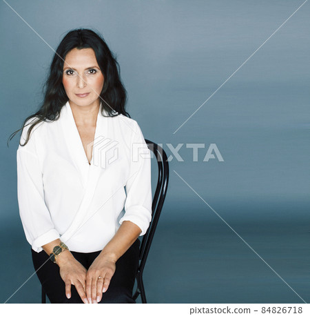 pretty brunette confident mature woman sitting on chair in studio, lifestyle people concept pretty brunette confident mature woman sitting on chair in studio, lifestyle people concept 84826718
