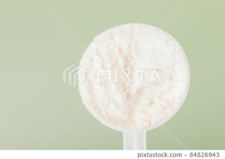 Whey protein powder in measuring spoon close up 84826943