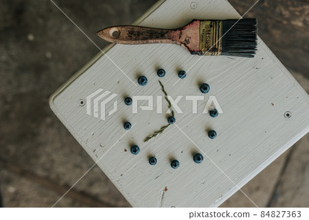 berries folded in a circle in the shape of a clock. blue paint brush 84827363