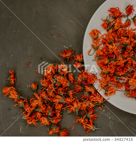 Dried flowers in a gray plate, orange calendula. Dried flowers in a gray plate, orange calendula. 84827418