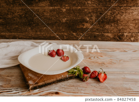Juicy red strawberry lies on the wooden board Juicy red strawberry lies on the wooden board 84827458