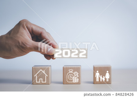 Start success business new year 2022, beginning business successful, Hand holding wood cubes with New year 2022 and goal or home and family icon. concept of New year Business goals and vision. 84828426