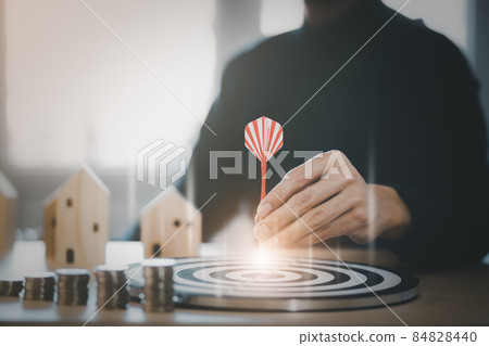 Targeting the business concept, Businessman touch red arrow dart to the virtual target dartboard, Executive marketing, investment goal and target for business investment concept, mini home. 84828440