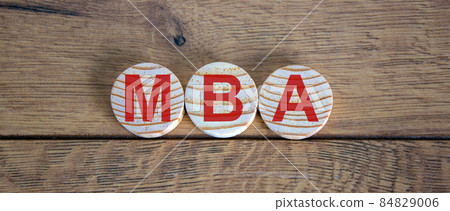 Concept word MBA on circles on a beautiful wooden table. 84829006