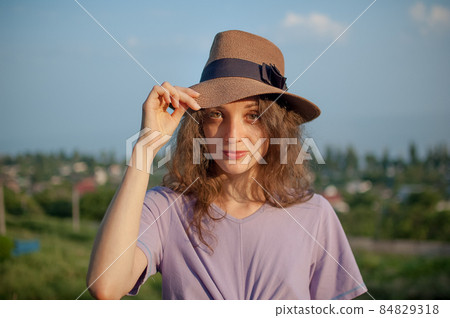 Young girl in dress is having great time during vacation in the summer on sky background in nature, travelling concept 84829318