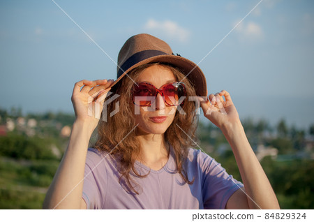 Young girl in dress is having great time during vacation in the summer on sky background in nature, travelling concept Young girl in dress is having great time during vacation in the summer on sky background in nature, travelling concept 84829324
