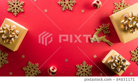 Christmas and new year background concept. Top view of Christmas gift box, reindeer, christmas ball and snowflake on red background. Christmas and new year background concept. Top view of Christmas gift box, reindeer, christmas ball and snowflake on red background. 84831171