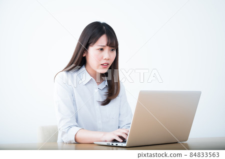 A woman with a difficult expression in front of a computer A woman with a difficult expression in front of a computer 84833563