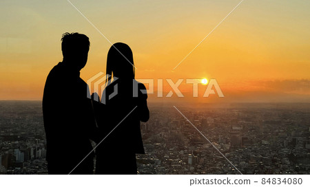 Silhouette of a couple overlooking the sunset in Tokyo_wide 84834080