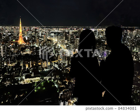 Silhouette of a couple overlooking Tokyo Tower and the night view of Tokyo 84834081