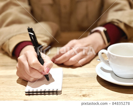 一個女人在咖啡館做筆記的手 84835278