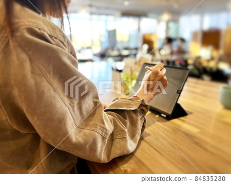 一位女士在咖啡館裡用筆操作平板電腦 一位女士在咖啡館裡用筆操作平板電腦 84835280