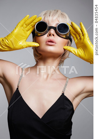 Unusual futuristic glasses. beautiful blonde hair woman in gloves and sunglasses 84835454