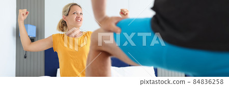 Enthusiastic woman sitting in bed with her hands up in front of man underwear 84836258