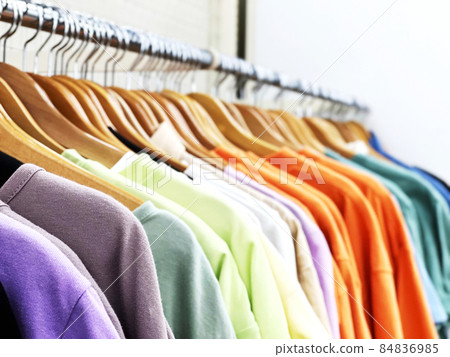 Colorful T-shirts displayed on hangers 84836985