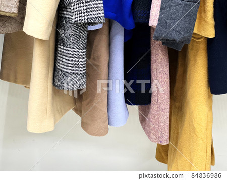 The hem of the coats lined up in the closet 84836986