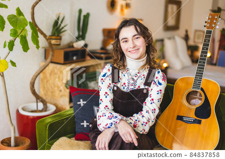 A woman playing the guitar 84837858