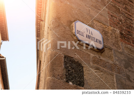Lucca, Tuscany, Italy. August 2020. The plaque of the street of the amphitheater, historic center. 84839233