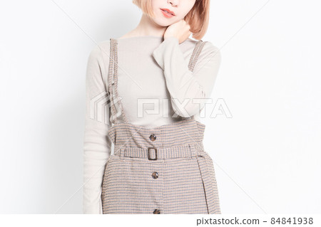 一個年輕的女孩站在白色背景前,肩膀僵硬擺姿勢 一個年輕的女孩站在白色背景前,肩膀僵硬擺姿勢 84841938