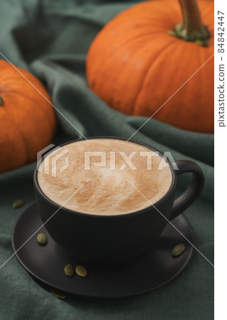 Pumpkin spicy latte in black cup on linne cloth Pumpkin spicy latte in black cup on linne cloth 84842447