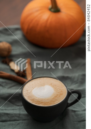 Pumpkin spicy latte in black cup on linne cloth Pumpkin spicy latte in black cup on linne cloth 84842452