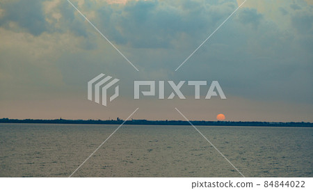 Beautiful Landscape of the Sunset on the Beach. Calm Weather with Blue Clouds in the Blue Sky Reflected in the Water Beautiful Landscape of the Sunset on the Beach. Calm Weather with Blue Clouds in the Blue Sky Reflected in the Water 84844022