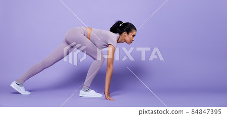 Full length Asian slim Fitness woman exercise warm up stretch spring jumps legs, peri purple 84847395