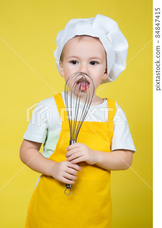 Little Boy playing chef, boy in apron holding a whisk for whipping 84847415