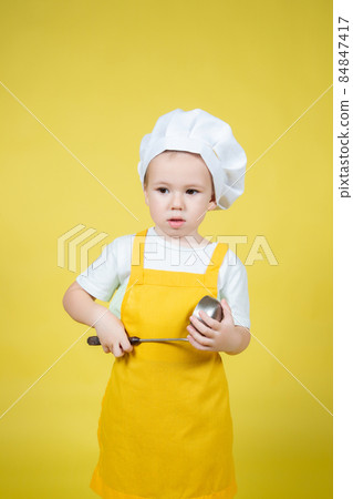 Little Boy playing chef, boy in apron and chef's hat emotionally posing 84847417