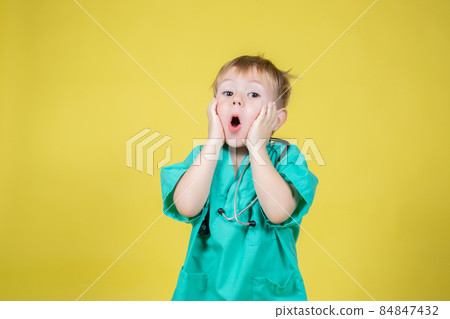 Portrait of shocked little boy dressed in doctors green posing emotionally 84847432