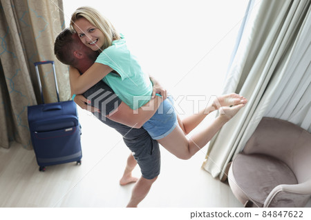 Happy wife smile and jump in hands to loved husband, meet man from work trip Happy wife smile and jump in hands to loved husband, meet man from work trip 84847622