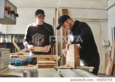 We love your company. Busy carpenters in uniform working with wood. 84850759
