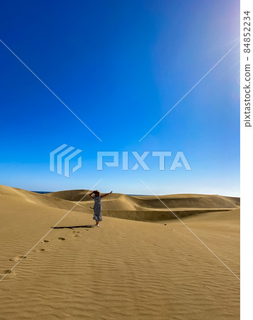 Silhouette of a woman in the desert, footprints in the sand 84852234