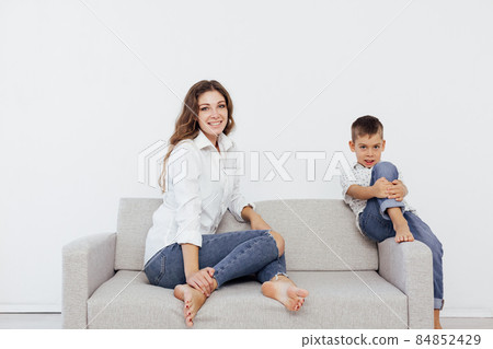 mother and son sit on the gray sofa of the house 84852429