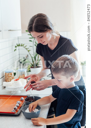 mother and son prepare sweet desserts in the kitchen mother and son prepare sweet desserts in the kitchen 84852473