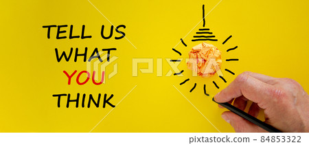 Support symbol. Businessman writing 'tell us what you think', isolated on beautiful yellow background. Light bulb icon. Business and support concept. Copy space. Support symbol. Businessman writing 'tell us what you think', isolated on beautiful yellow background. Light bulb icon. Business and support concept. Copy space. 84853322
