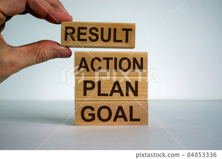 Male hand placing a blocks with word 'result' on top of a blocks tower. Beautiful white background. 84853336