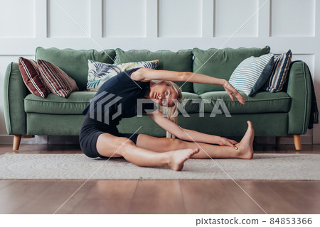 Woman doing side bend exercise, working out at home. Woman doing side bend exercise, working out at home. 84853366